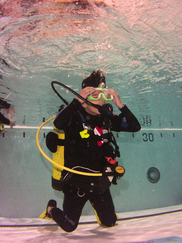 young adaptive diver adjusting scuba mask underwater